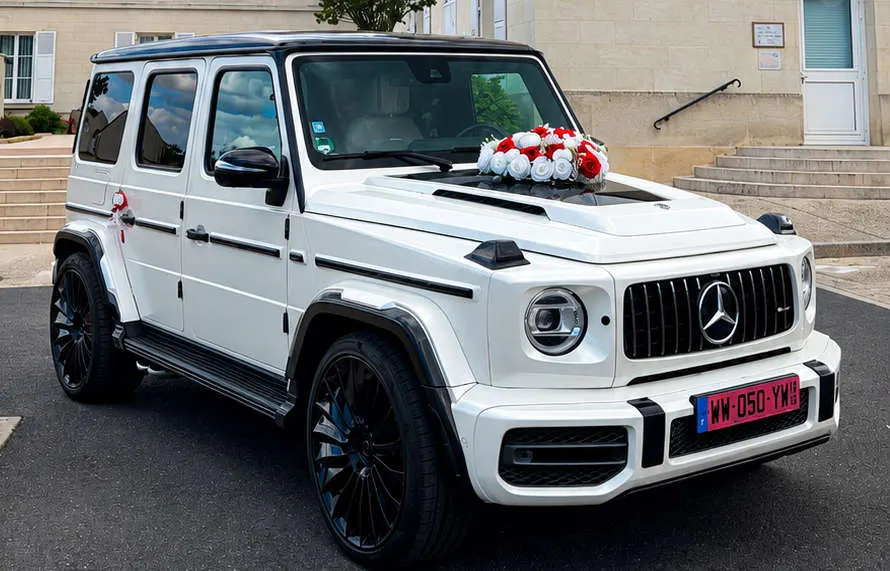 Mercedes Classe G blanche décorée d'un bouquet de fleurs rouges et blanches, vue avant trois-quarts
