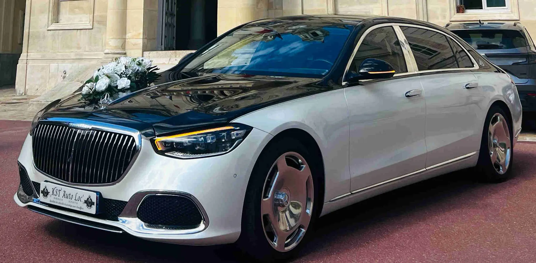 Mercedes Classe S Maybach bicolore blanc et noir, un bouquet de fleurs blanches sur le capot, vue avant trois-quarts